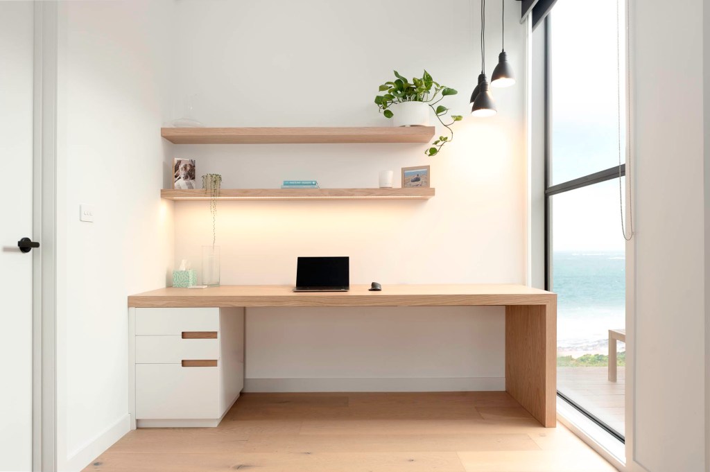 Custom white and timber desk with lighting and shelves