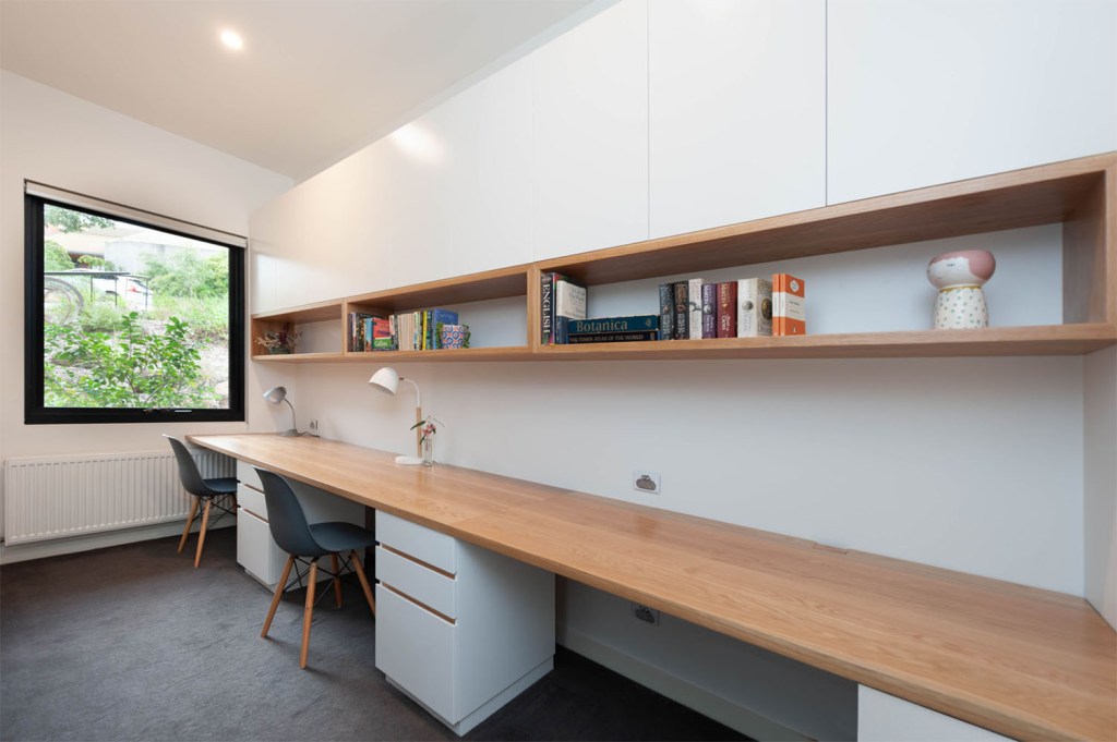 Custom fitted long desk and shelving above and desk pedestals