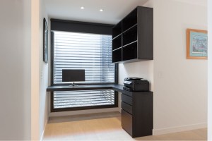 Corner black home office desk with floating shelving